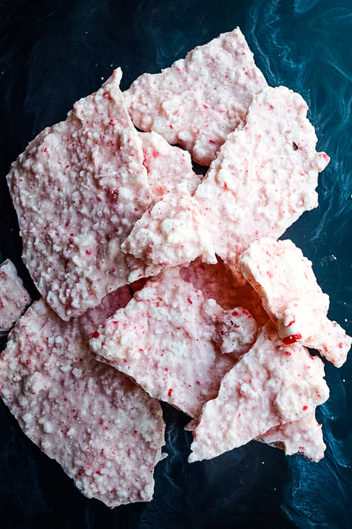 white chocolate peppermint candy shards on blue background