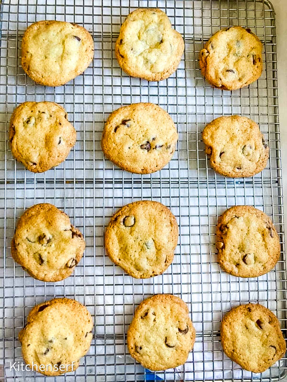 12 chocolate chip cookies arranged on a wire rack. 