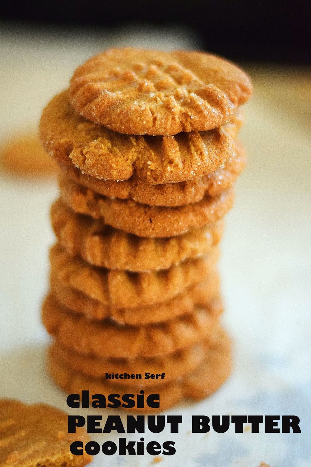 A tall stack of classic peanut butter cookies rests on a light surface, with "PEANUT BUTTER cookies" written below.
