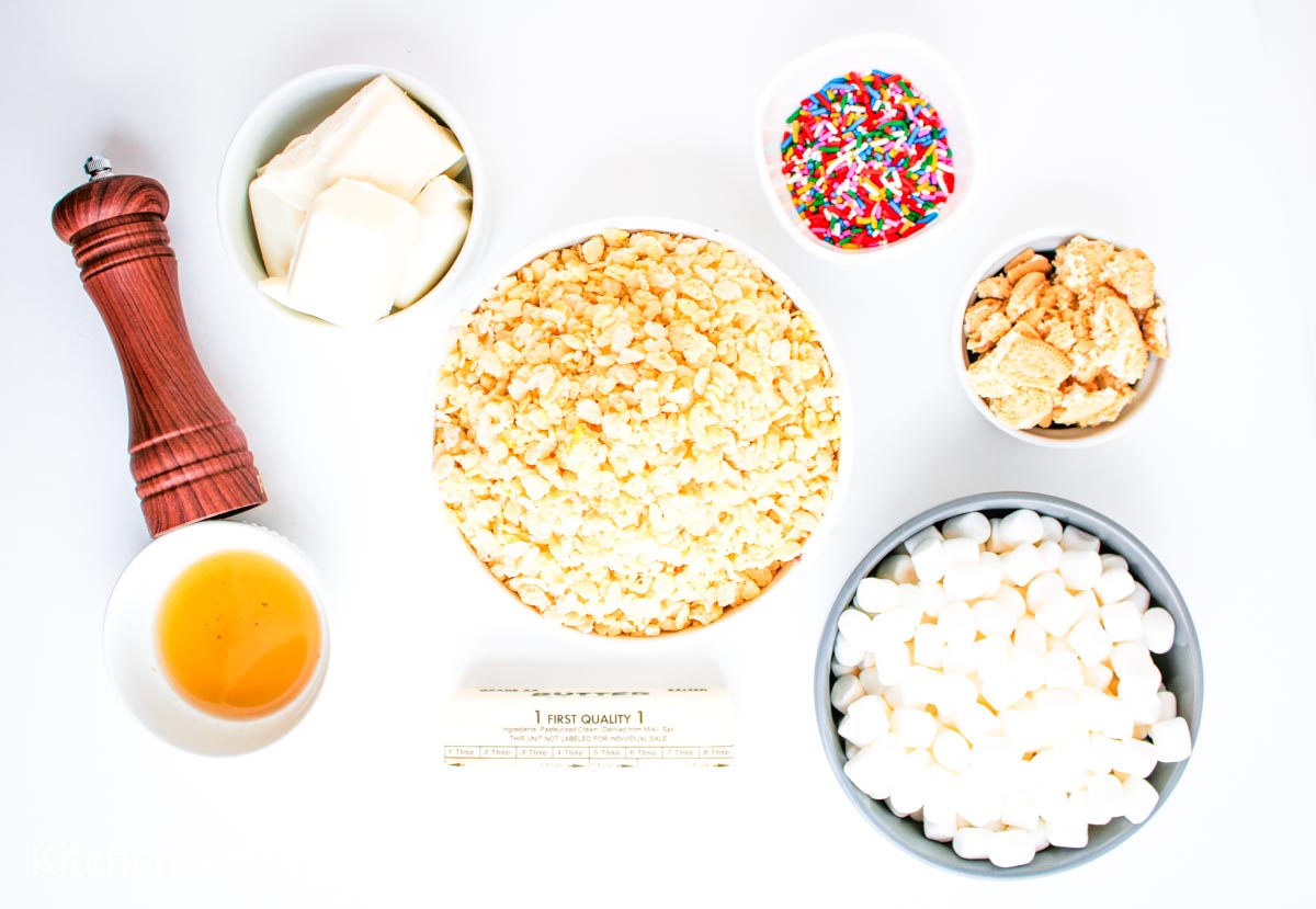 Bowls of cereal, marshmallows, sprinkles, butter, vanilla, and white chocolate, plus a pepper grinder.