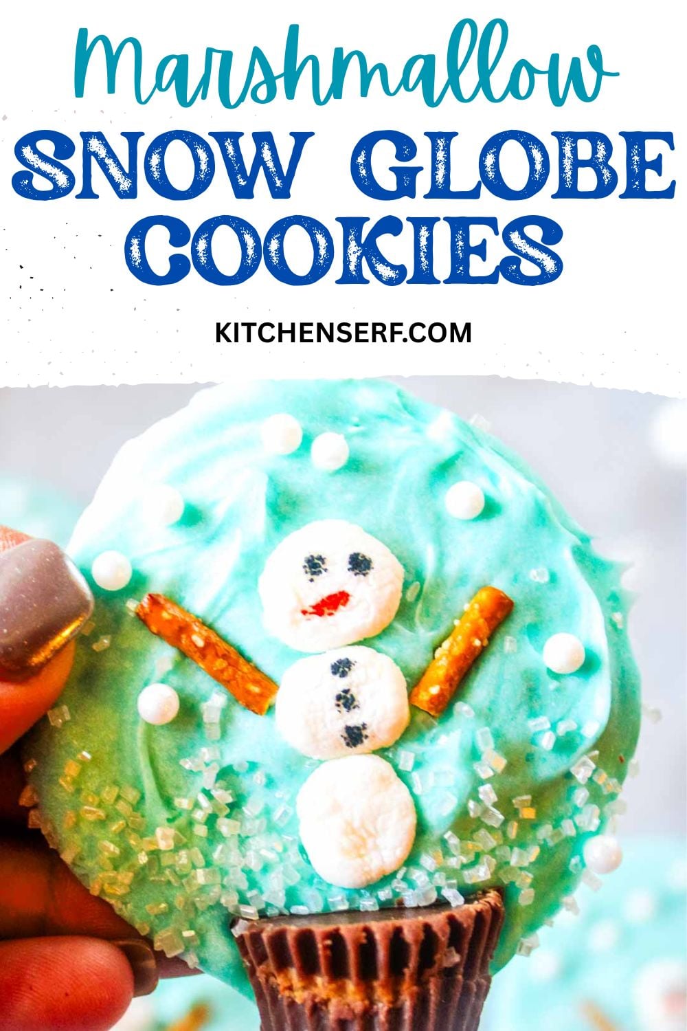 Close-up of a decorated marshmallow snow globe cookie topped with a snowman made of marshmallows, pretzel stick arms, and sparkling sugar sprinkles.