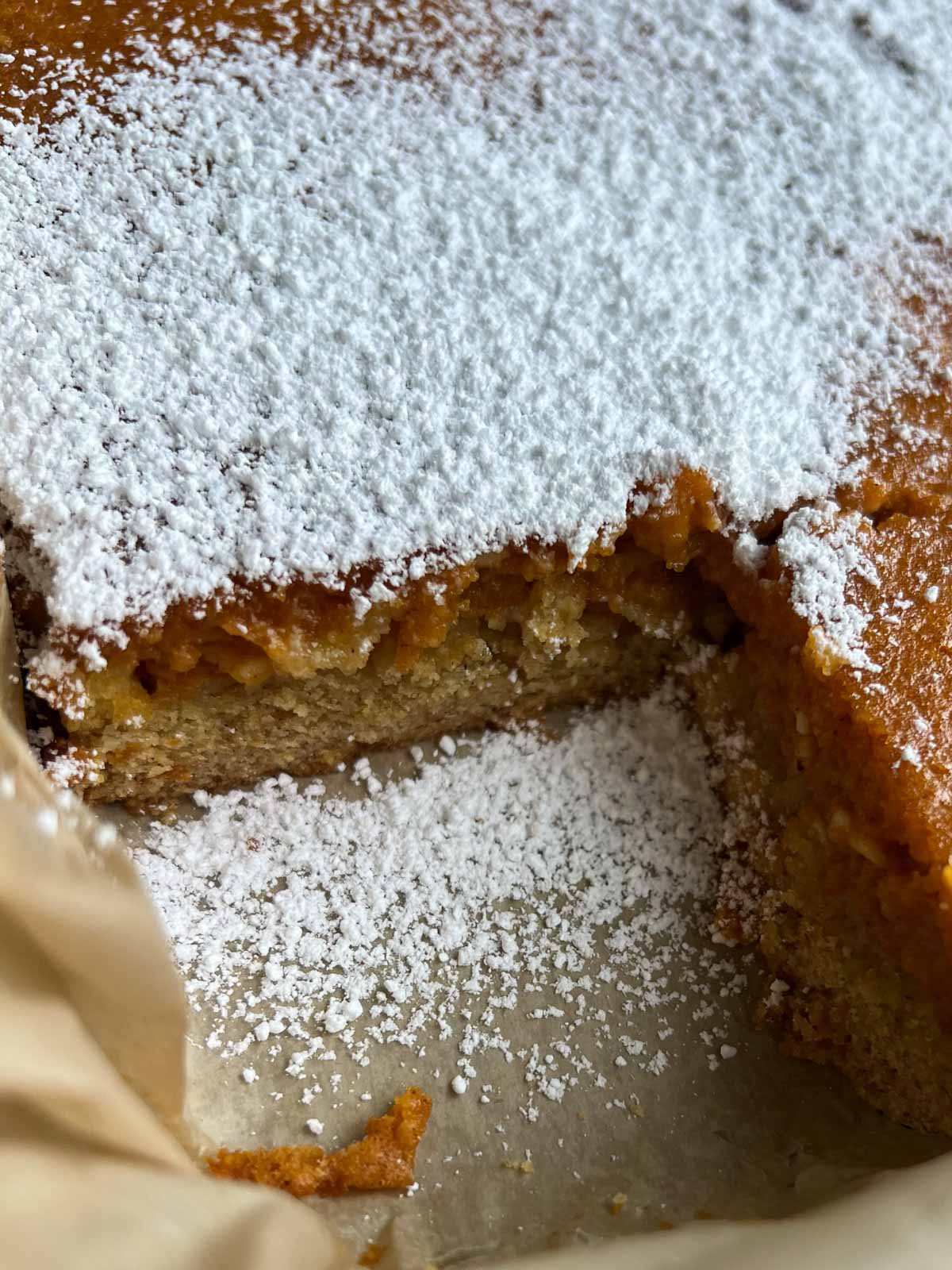 corner of pumpkin cake with slice taken out of it.