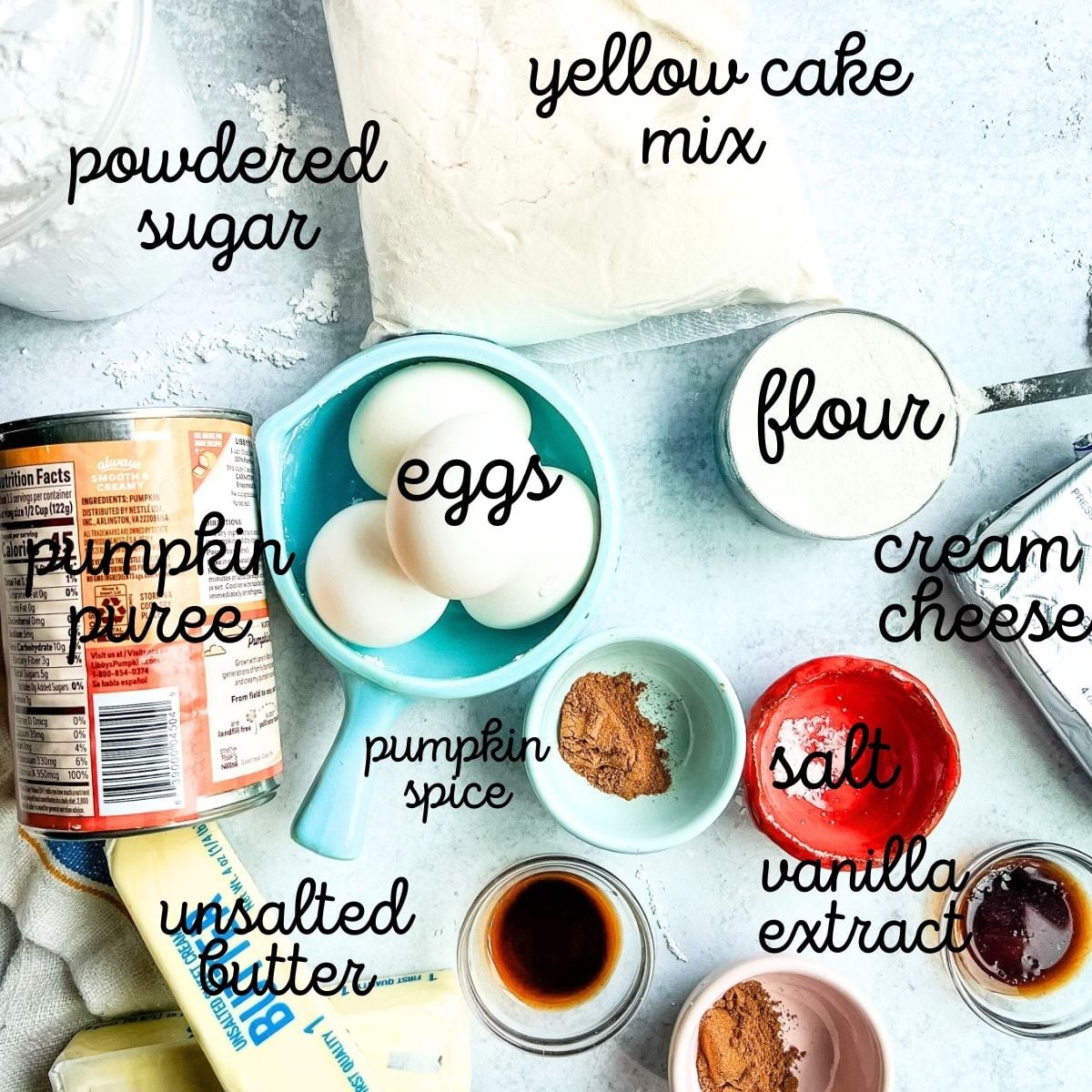 pumpkin gooey butter ingredients include pumpkin puree, cream cheese, butter and cake mix on marble board.