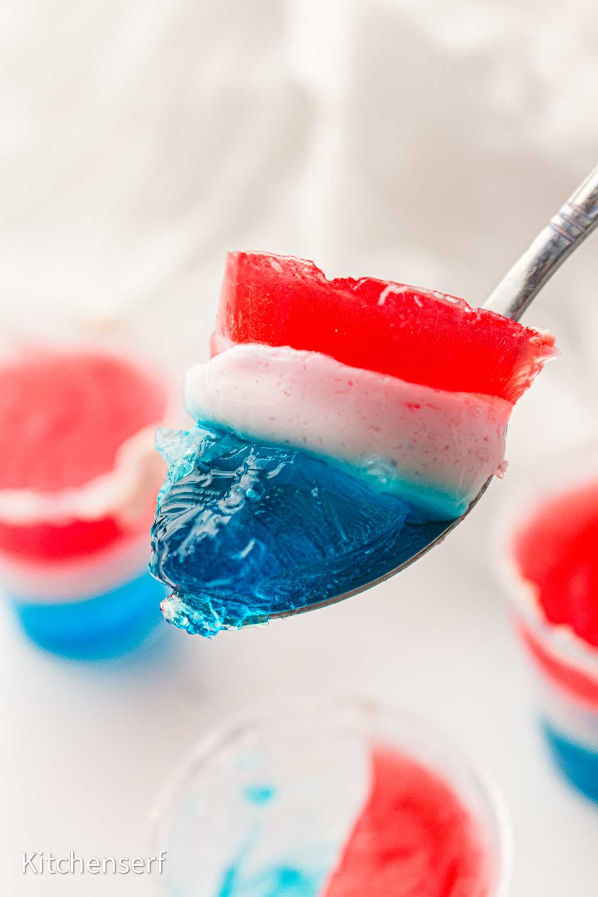 Red, white, and blue layered jello on a spoon.