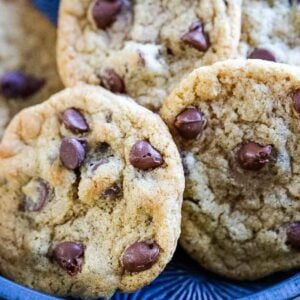 Close-up of chocolate chip cookies stacked on a blue plate.